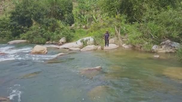 Fiskare står på tropiska berg floden — Stockvideo