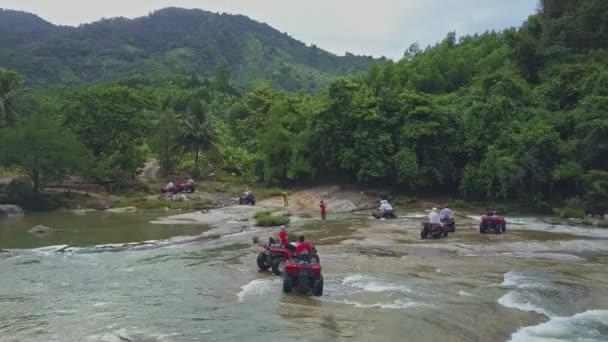 As pessoas dirigem quadriciclos ao longo do rio poderoso — Vídeo de Stock