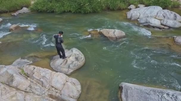 Чоловік підкидає рибальську мережу в річку — стокове відео