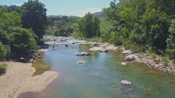 Mann steht in klarem Wasser und repariert Fluss — Stockvideo