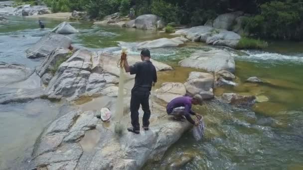 Chicos sentados en piedra grande — Vídeo de stock