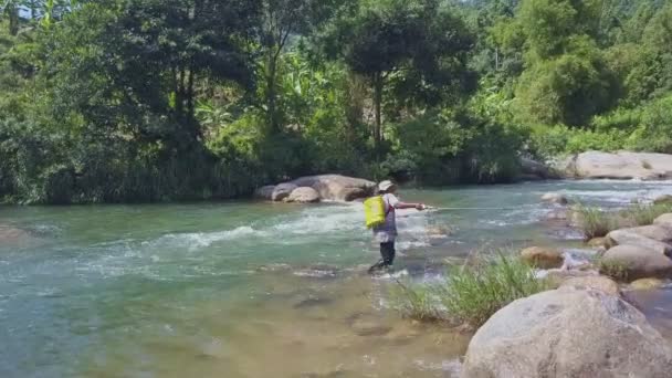 Человек с удочкой прогулки вдоль реки — стоковое видео