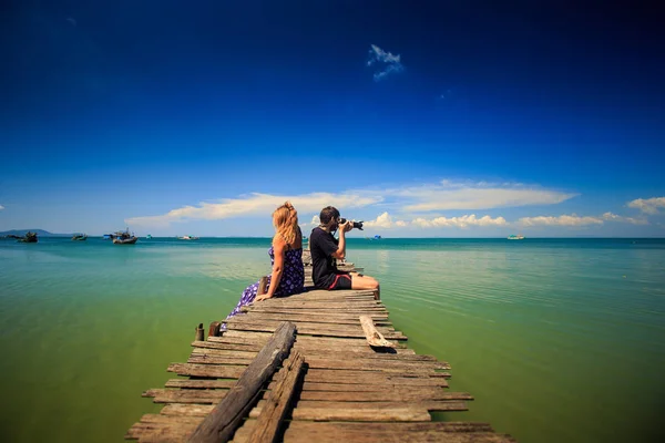Парень и женщина сидят на причале у моря — стоковое фото