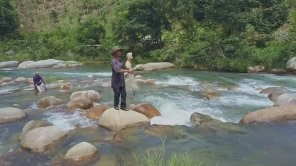 漁師川の中の石から石へのジャンプします。 — ストック動画