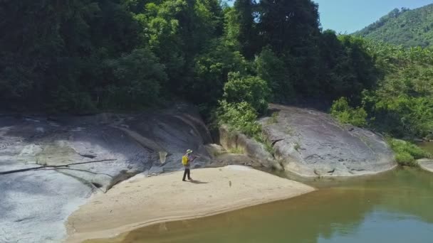 Hombre con caña de pescar camina a lo largo del río — Vídeo de stock