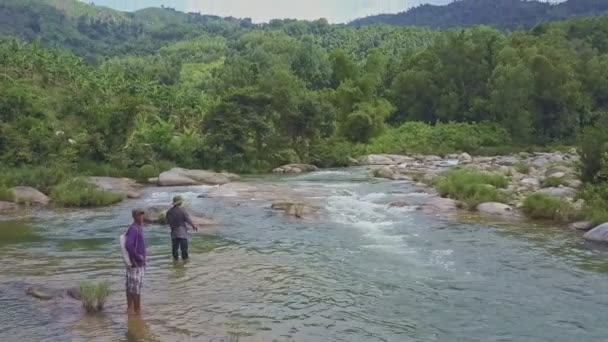 Hombres caminando en la orilla rocosa y la pesca — Vídeos de Stock