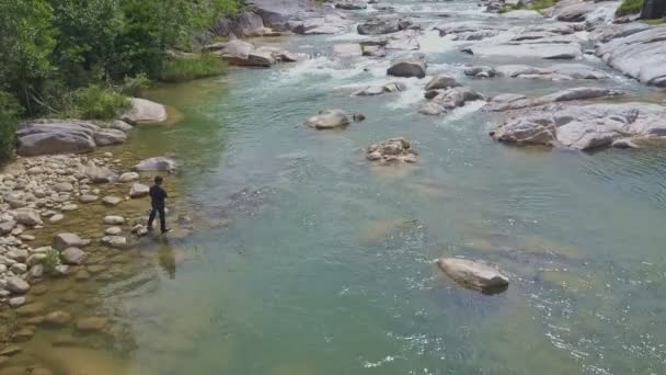 Chico pescando con red en río de montaña — Vídeo de stock