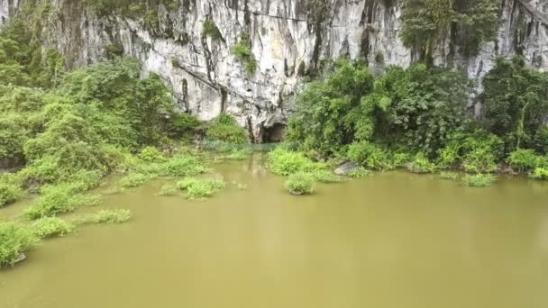 Lake with tropical plants on bank to cave — Stock Video