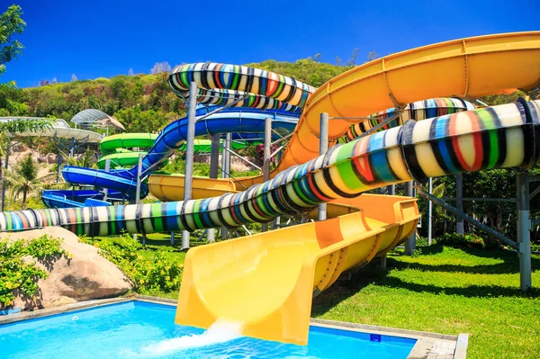 Tubes colorés de glissières d'eau dans le parc aquatique tropical — Photo