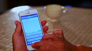 Kiev/Ukrayna - 07 Aralık 2015: Iphone kötü beyaz masa örtüsü ve içecek fincan masada oturan kız türleri iletide yaktı Oda 07 Aralık Kiev