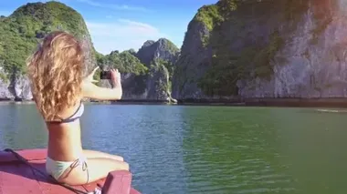 kamera yan görünümü ince seksi uzun saçlı kız bikini selfie sakin azure karşı büyük sarp kayalar tarafından defne yapma gösterir