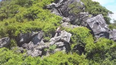 atletik kız büyük kayalar tırmanıyor