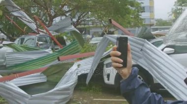 Nha Trang/Vietnam - 05 Kasım 2017: motosikletçi video yıkılan binaların çatıları üzerinde 05 Kasım Nha Trang içinde tayfun sonra tüm araçlar üzerinde dağınık kask yapar