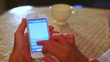 Kiev/Ukrayna - 07 Aralık 2015: Smartphone ekranda beyaz masa örtüsü ve içecek fincan ile kötü masada oturan kız türleri iletisi yaktı Oda 07 Aralık Kiev