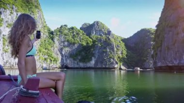 ünlü bay selfie karşı kayalık adalar yapım tekne seyahat eden seksi uzun saçlı kız kamera gösterir