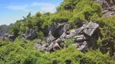 atletik kız büyük kayalar tırmanıyor