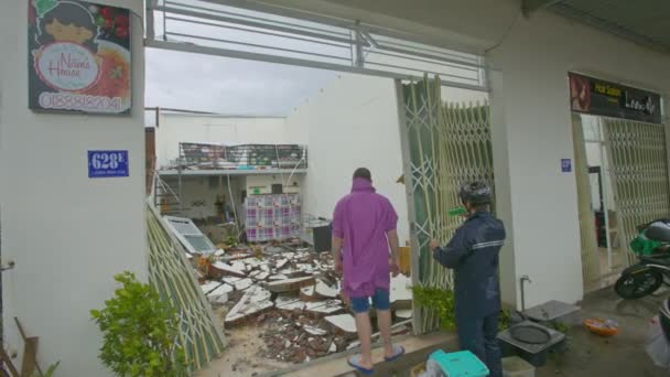 Nhatrang 2017年11月04日 在强大的飓风造成可怕的后果在11月04日在 Nhatrang 在倒塌的屋顶行走的人在被破坏的大厦 — 图库视频影像