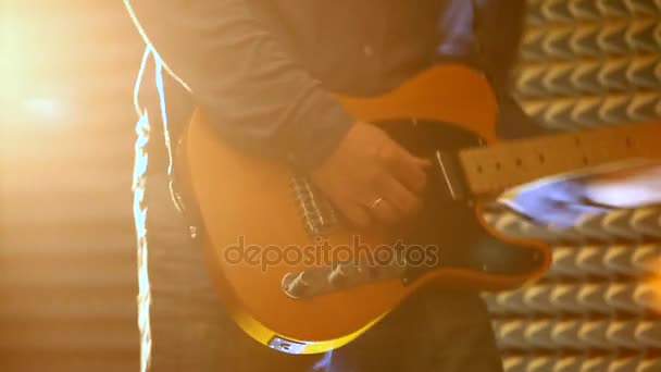 リングでマクロ男の手の壁に明るいライトの下で スタジオでエレク トリック ギターを果たしています — ストック動画