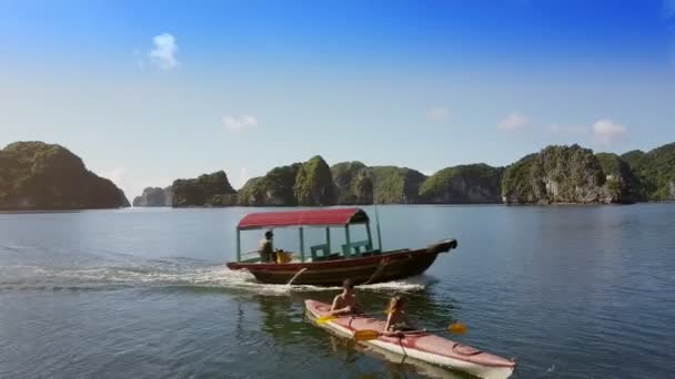 Couple in kayak sails on azure bay and boat — Stock Video