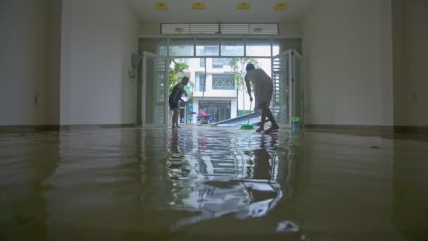 Nhatrang 2017年11月04日 妇女人清除洪水从房间地板用笤帚作为后果在强的雨期间在破坏性的台风期间在11月04日在 Nhatrang — 图库视频影像