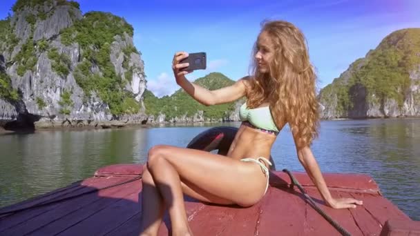 水着でクローズ アップ素敵なセクシーなブロンドの女の子は Azure 湾風揺れる長い髪に対してボートの Selfie — ストック動画