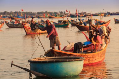 MUI KD/Vietnam - 17 Mart 2016: büyük tekne içinde Asya balıkçı çeker küçük Yalı ve berrak gökyüzü karşı iple mavi tekne turu 17 Mart MUI Ne içinde