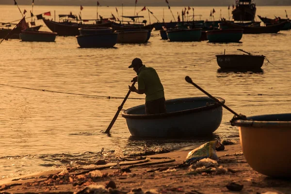 MUI KD/Vietnam - 17 Mart 2016: balıkçı siluet satırları altında balıkçı teknesi, sahil şeridi günbatımı ve uzun tekne Vietnam karşı oynamaya 17 Mart MUI Ne içinde yuvarlak