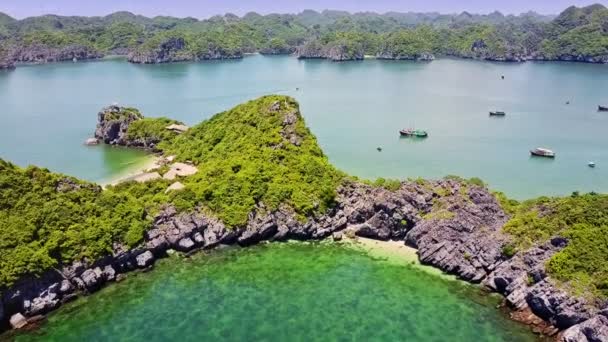 ラウンド ラグーンと青い空と海の海岸にある小さな町の岩だらけの島の上の低速飛行 — ストック動画