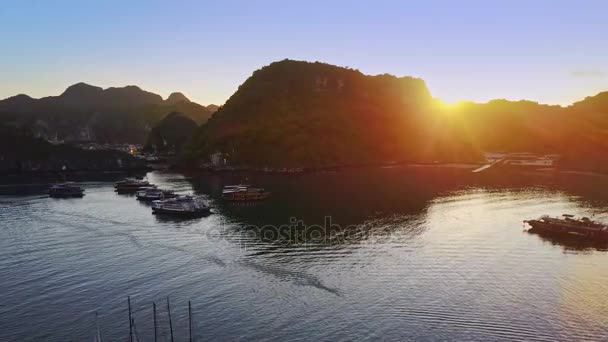 安静的海洋海湾与漂浮的村庄帆船和大岩石海岛反对美丽的日出 — 图库视频影像