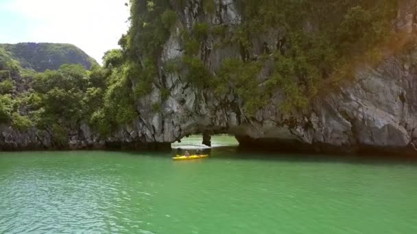 独木舟的人从大悬崖的洞穴中航行 被反射的阳光作为自然现象 明亮地照亮了拱顶 — 图库视频影像