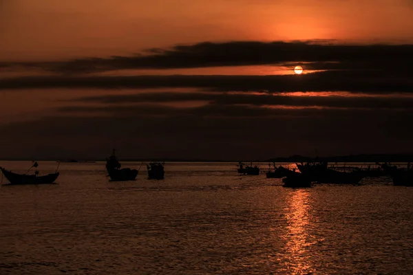 fantastic view fishing boat silhouettes melt into background in ocean bay at late dark sunset