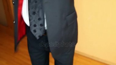 portre iyi giyimli damat siyah takım elbise ceket koyar ve tüysüz kollu düğün için pansuman yukarıya kaldırır