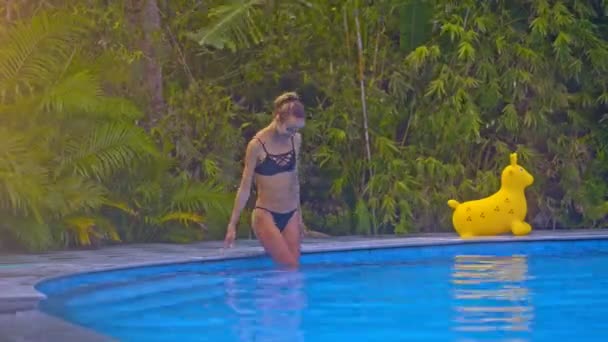 Pretty Blond Girl Black Swimsuit Goes Water Hotel Pool Edge — Stock Video