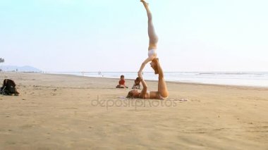 Goa, Hindistan - 09 Aralık 2012: Yan görünümü kadın ortak baş karşı inanılmaz derecede sakin deniz 09 Aralık Goa içinde tutarak beyaz mayo mu Yoga