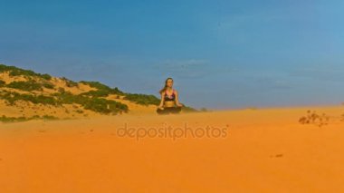 yoga lotus pozisyonda golden sand dune nadir bitki ve mavi gökyüzü karşı top konsantre kız meditasyon