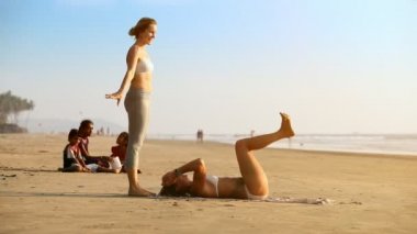 Goa, Hindistan - 09 Aralık 2012: Genç kızlar dinlenme ve ortak yoga yaparken başlangıç başarısız karşı yerel çocuk kum plajı üzerinde 09 Aralık Goa içinde poz