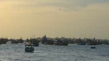 Ağır fırtına günbatımı ışık karşı sonra okyanustaki dalgalar arasında defne Vietnamca geleneksel balıkçı tekneleri drift