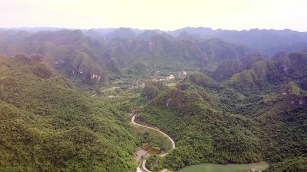 絵ドローンが緑の谷に沿ってジャングルとうねる道美しい丘陵の風景を表示します — ストック動画
