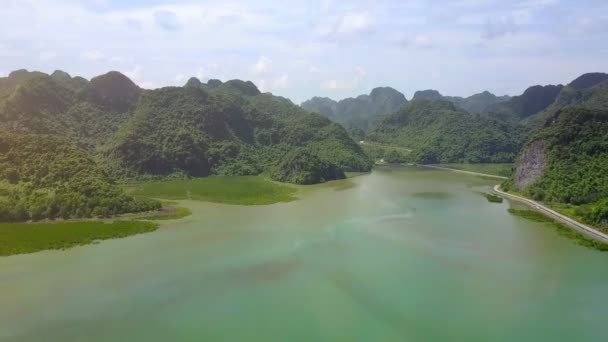 Drone Menunjukkan Jalan Aspal Panjang Berkelok Kelok Sekitar Pulau Berbukit — Stok Video
