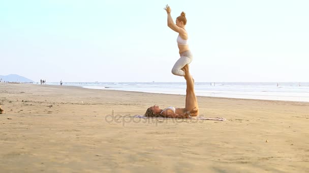 ビューの若い女の子は ゴアで 日海岸海で遠いスイミング人々 に対してのヨガの練習を行うゴア インド 2012 — ストック動画