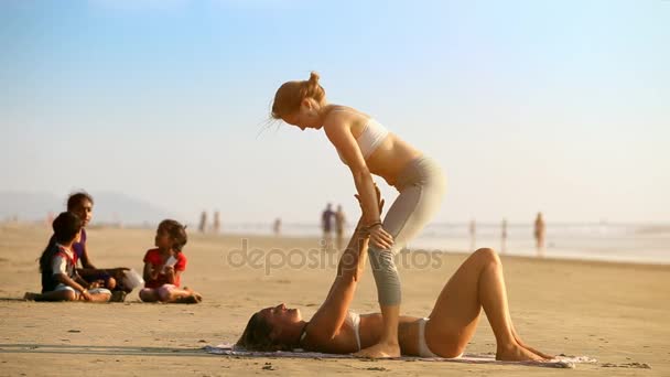 インド 2012 インド子供時計スリム女の子練習パートナー アクロ金髪少女あるゴアで 日海によって伸ばされた腕に友人を保持して — ストック動画