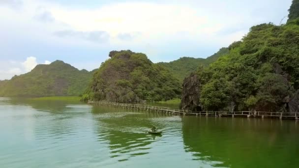 鸟瞰当地男子排船通过长木桥对著名的岛猫 在哈龙湾下的阴天 — 图库视频影像