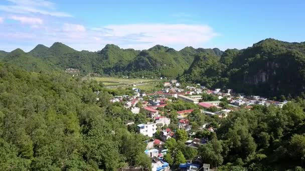 vue aérienne petite ville de villégiature moderne sur la côte de la baie de l'océan parmi les collines forestières verdoyantes contre le ciel bleu 