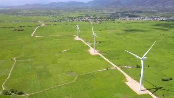 Panorâmica Aérea Torres Turbinas Eólicas Amplos Campos Verdes Contra Aldeias — Vídeo de Stock
