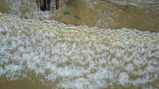 fermer vue aérienne océan vagues colorées par rivière argile laver la côte avec cadre de maison et transporter différentes ordures sur la plage 
