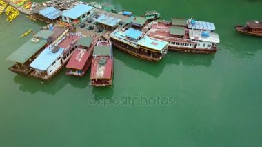 kamera yukarı taşır ve sarı spor kayaklarının ve geleneksel ahşap tekne yüzer iskeleler gösterir