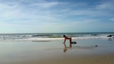 yoga pozlar yumuşak akan dalgalar ve sınırsız mavi gökyüzü karşı tropikal okyanus plaj üzerinde kız at kuyruğu ile değiştirir