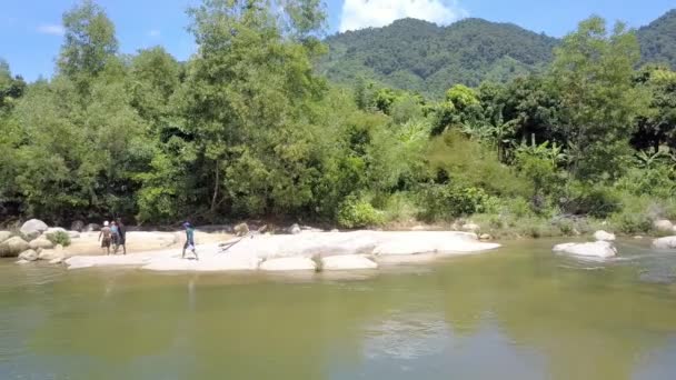 Nha Trang ベトナム 2017 漁師に川の銀行の岩の上を歩く裏面表示 日ニャチャンの青い空の下で熱帯林丘に対して釣り場所を選択します — ストック動画