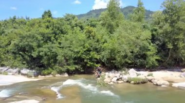Nha Trang/Vietnam - 26 Ağustos 2017: dron gösterir yerel çocuklar balık elektrik çubukları ile köpüklü river rapids su taşları yakınındaki Ormancılık banka üzerinden 26 Ağustos Nha Trang içinde
