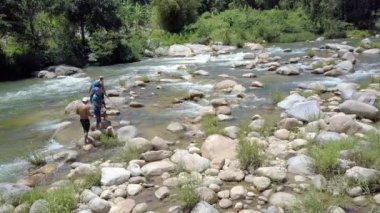 Nha Trang/Vietnam - 26 Ağustos 2017: Caps yerel erkekler yürümek rapids taşlar hakkında ve balık Nehri üzerinde 26 Ağustos Nha Trang içinde akış arasında elektrik çubukları yasaklama ile arka görünüm